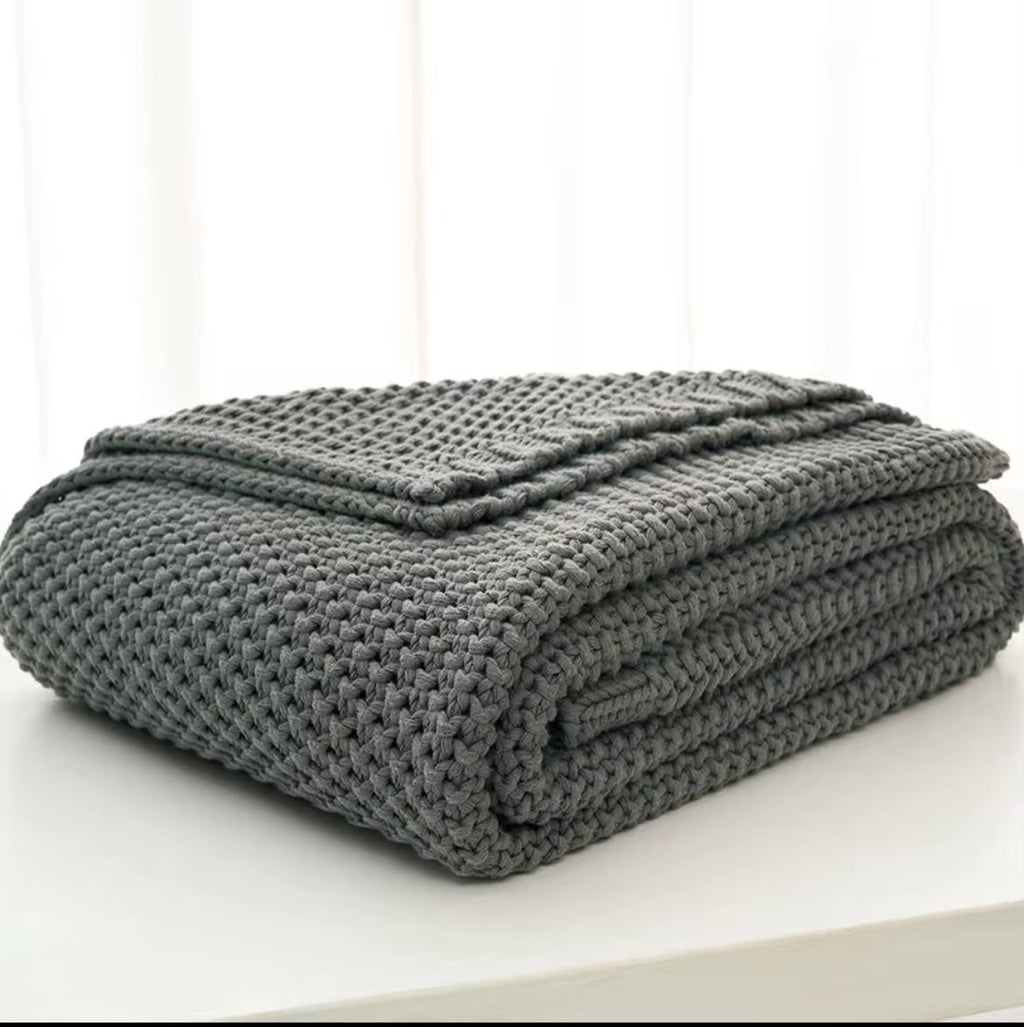Chunky knit throw blanket white folded on white surface Nordic style