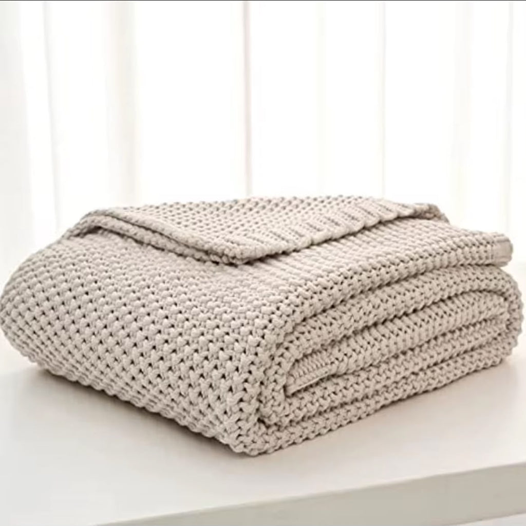 Chunky knit throw blanket forest green folded on white surface