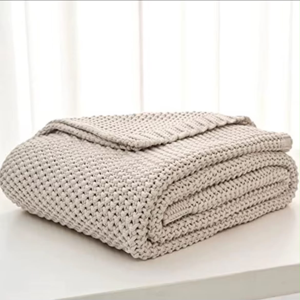 Chunky knit throw blanket forest green folded on white surface