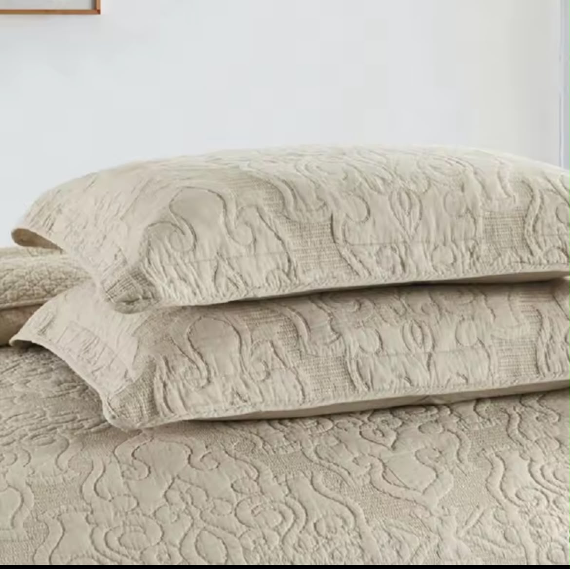 Two stacked natural beige embroidered cotton pillow shams with arabesque quilting pattern – close-up