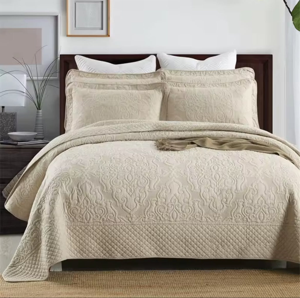 Natural beige embroidered cotton quilt set on king bed with matching pillow shams – full room view