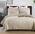 Natural beige embroidered cotton quilt set on king bed with matching pillow shams – full room view
