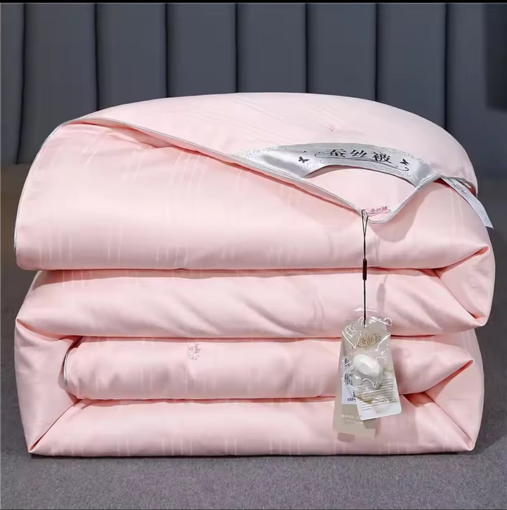 Luxury mulberry silk duvet folded in blush pink with satin label