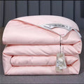 Luxury mulberry silk duvet folded in blush pink with satin label