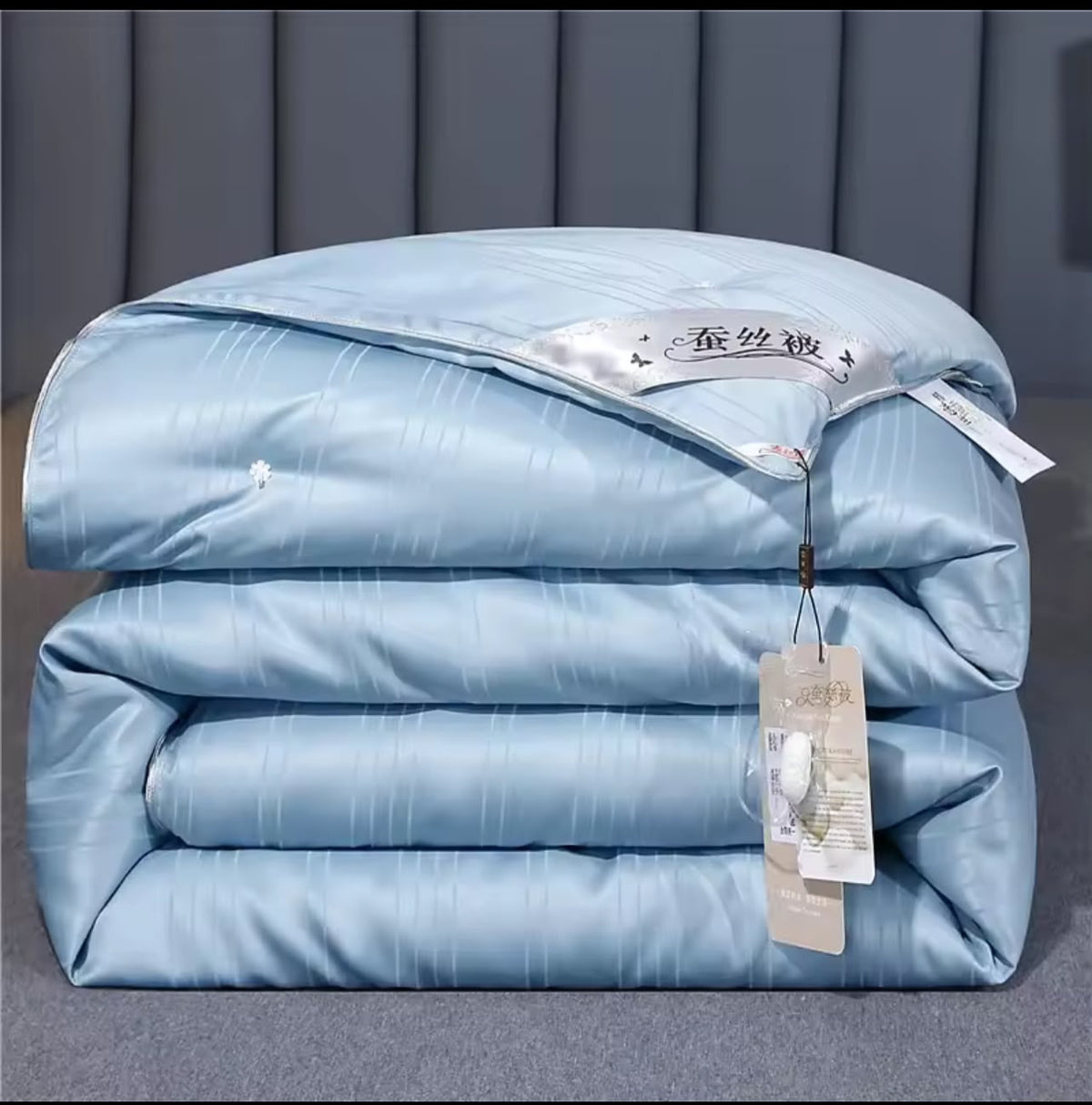 Luxury mulberry silk duvet folded in powder blue with satin label