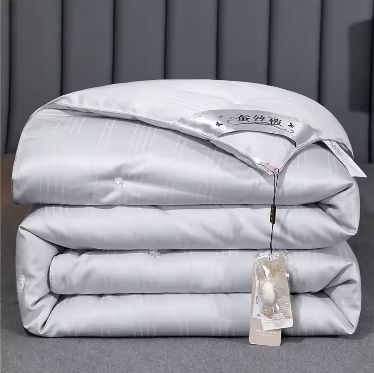 Luxury mulberry silk duvet folded in silver grey with satin label