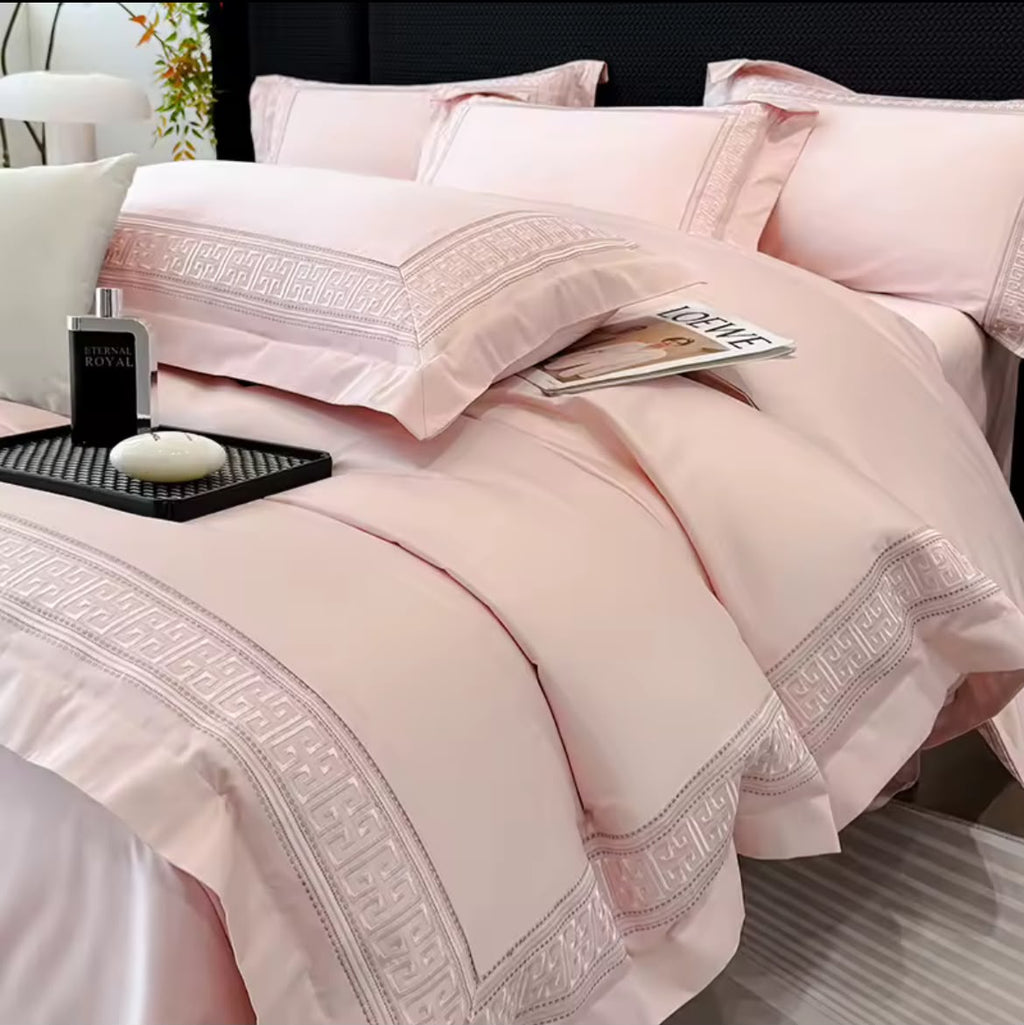 Blush pink Egyptian cotton duvet cover set with Greek key embroidery border on king bed – styled view