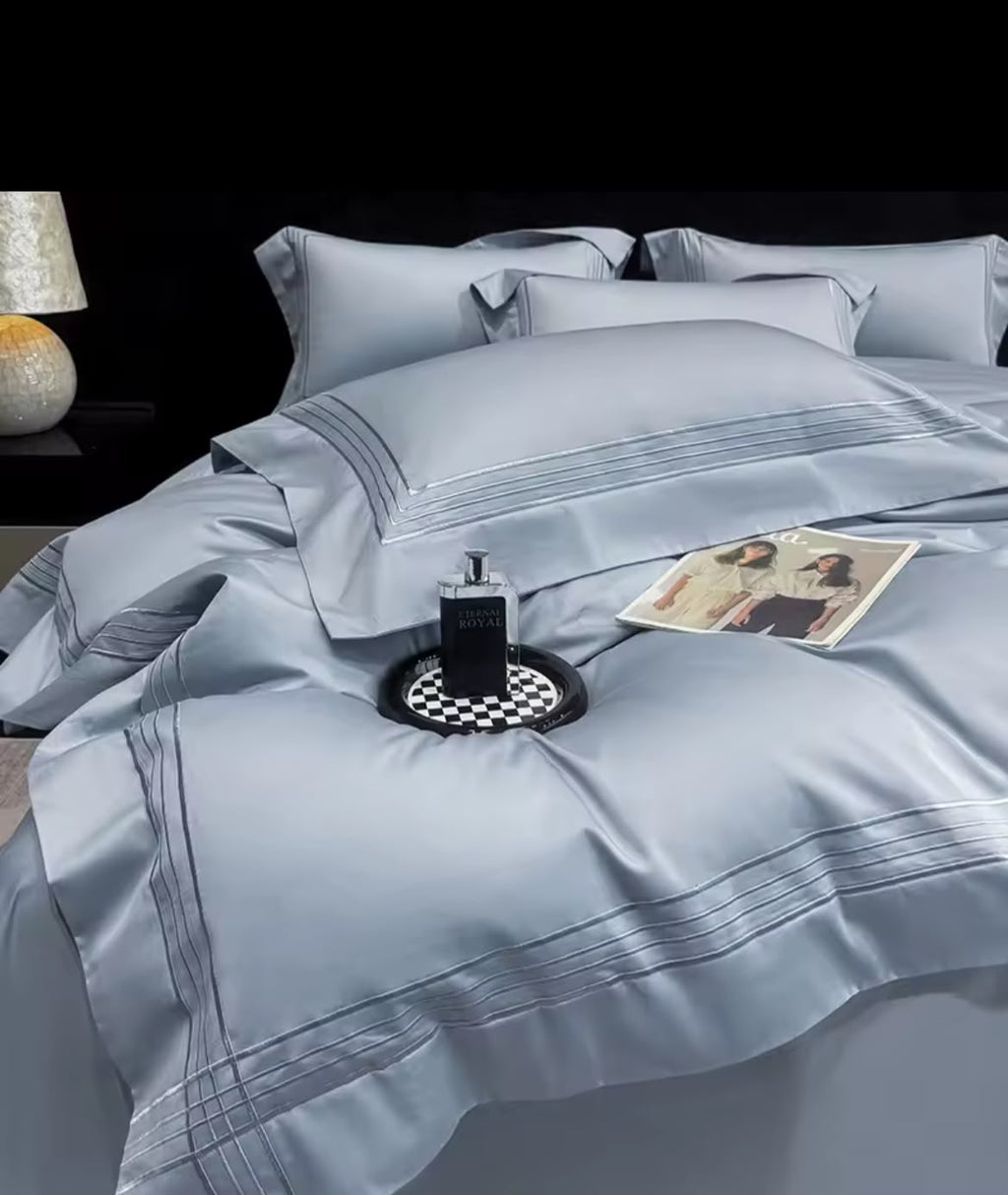 Steel blue Egyptian cotton duvet cover with triple-line embroidery on king bed – close-up view