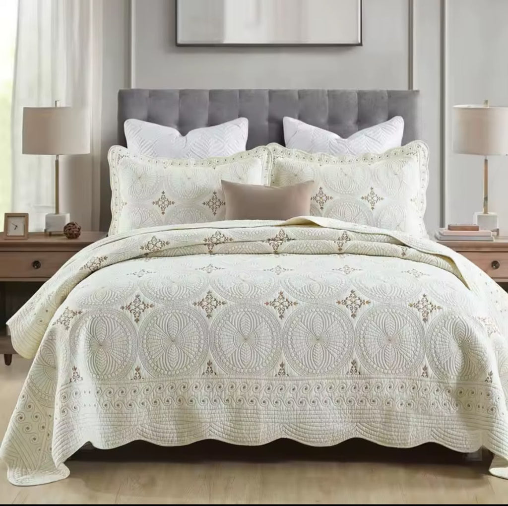 Close-up of ivory cotton embroidered bedspread with gold thread circular mandala pattern