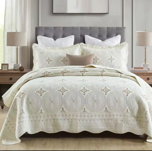 Close-up of ivory cotton embroidered bedspread with gold thread circular mandala pattern