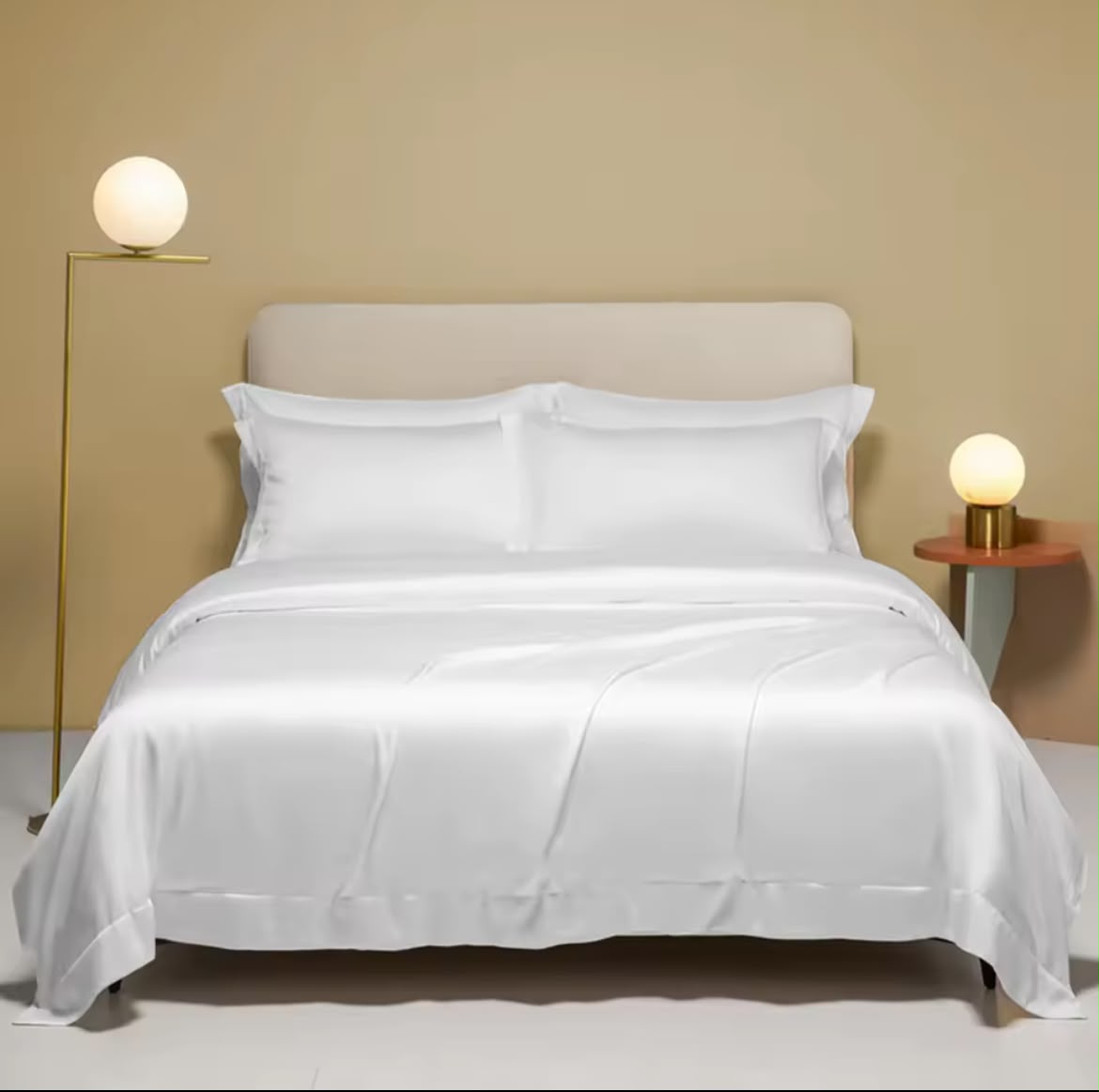 White silk-touch duvet cover set on a styled bed with warm lighting – full bed view