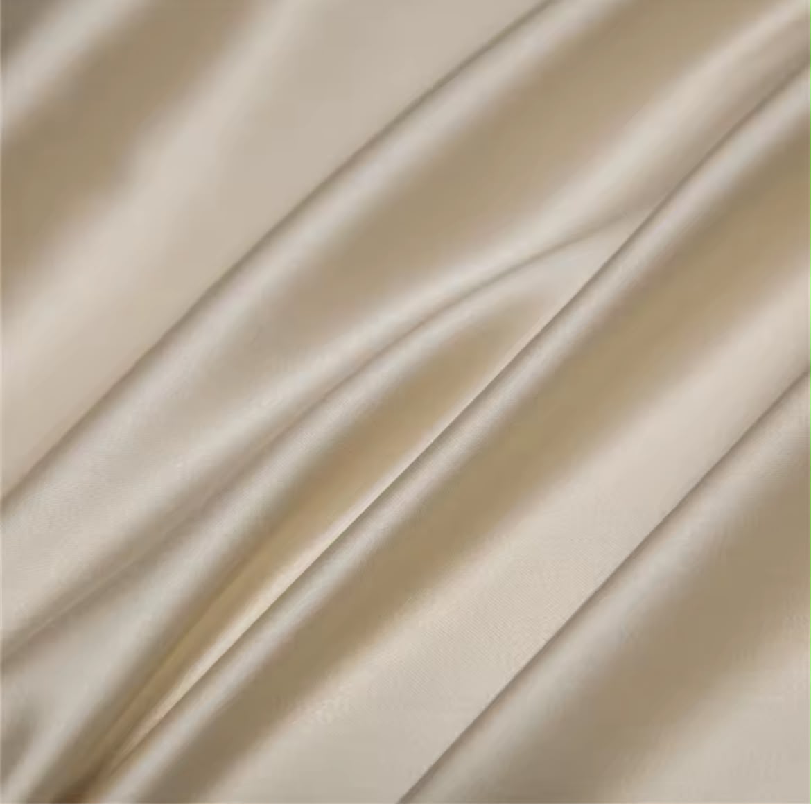Macro texture shot of champagne silk-touch fabric showing luxurious sheen and smooth weave