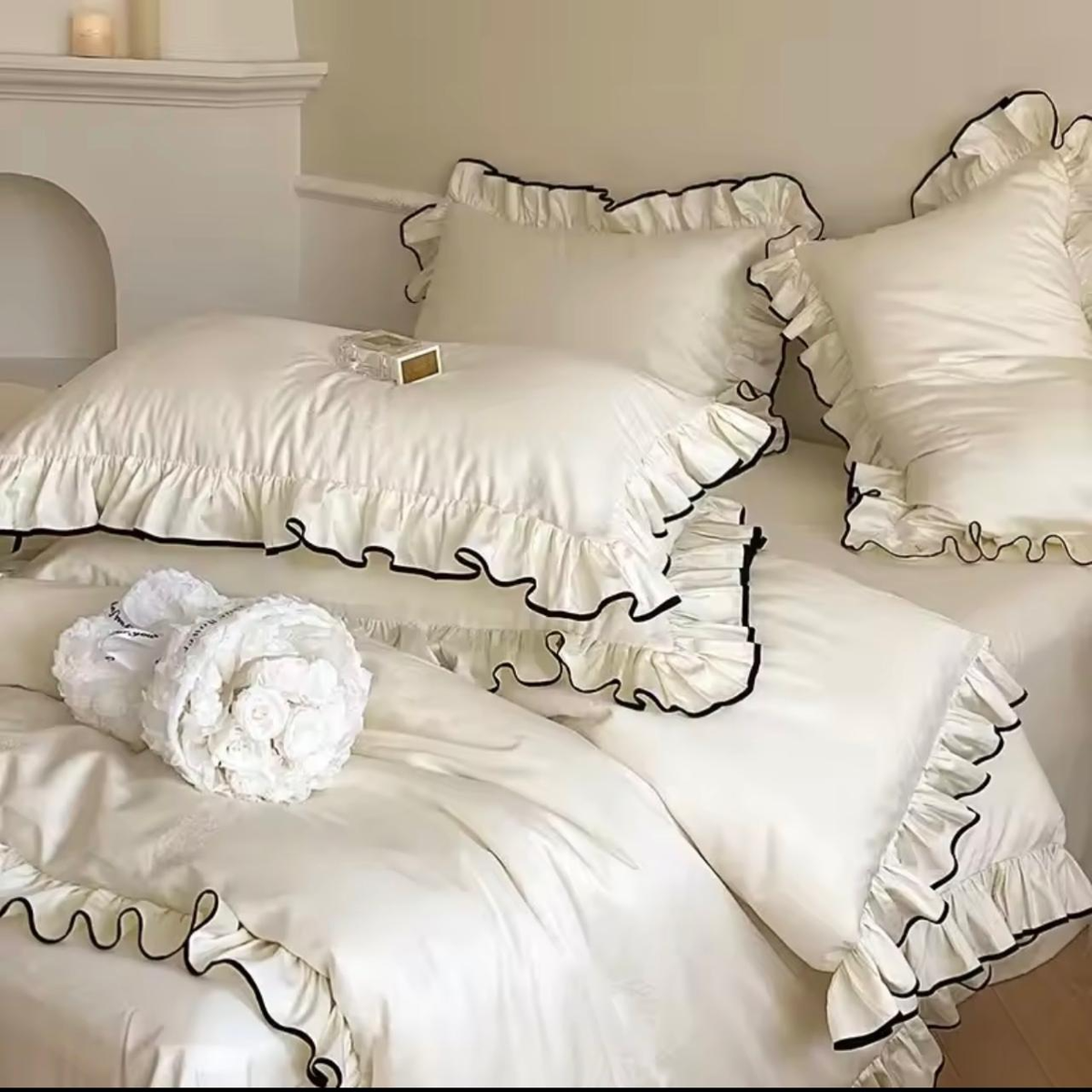 Off-white silk-touch duvet cover set with double ruffle and black trim on king bed – full view